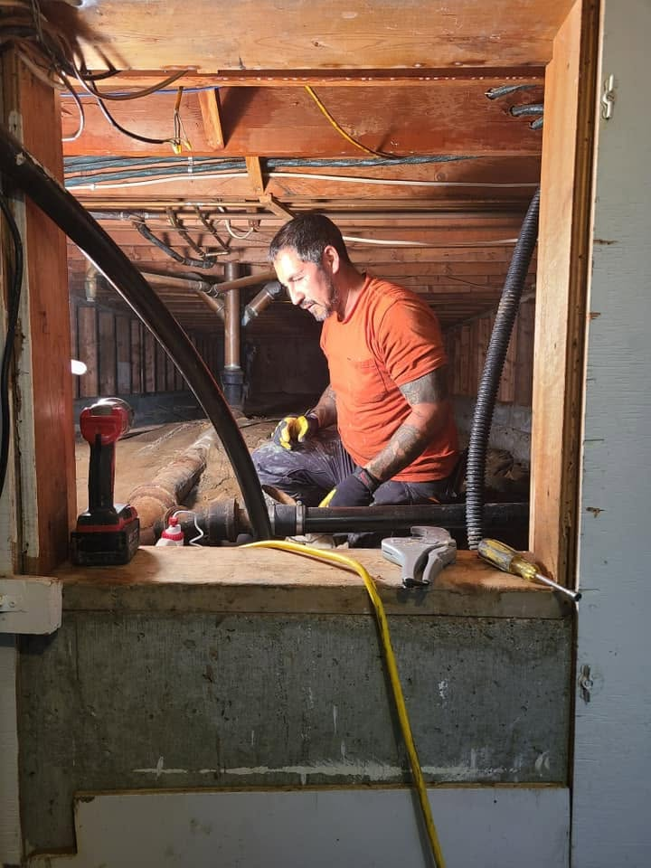 Liquid Empire technician working on subfloor plumbing